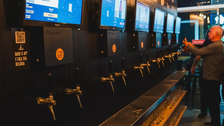 cliente utilizando sistema de autosserviço de chope Beerpass em bar