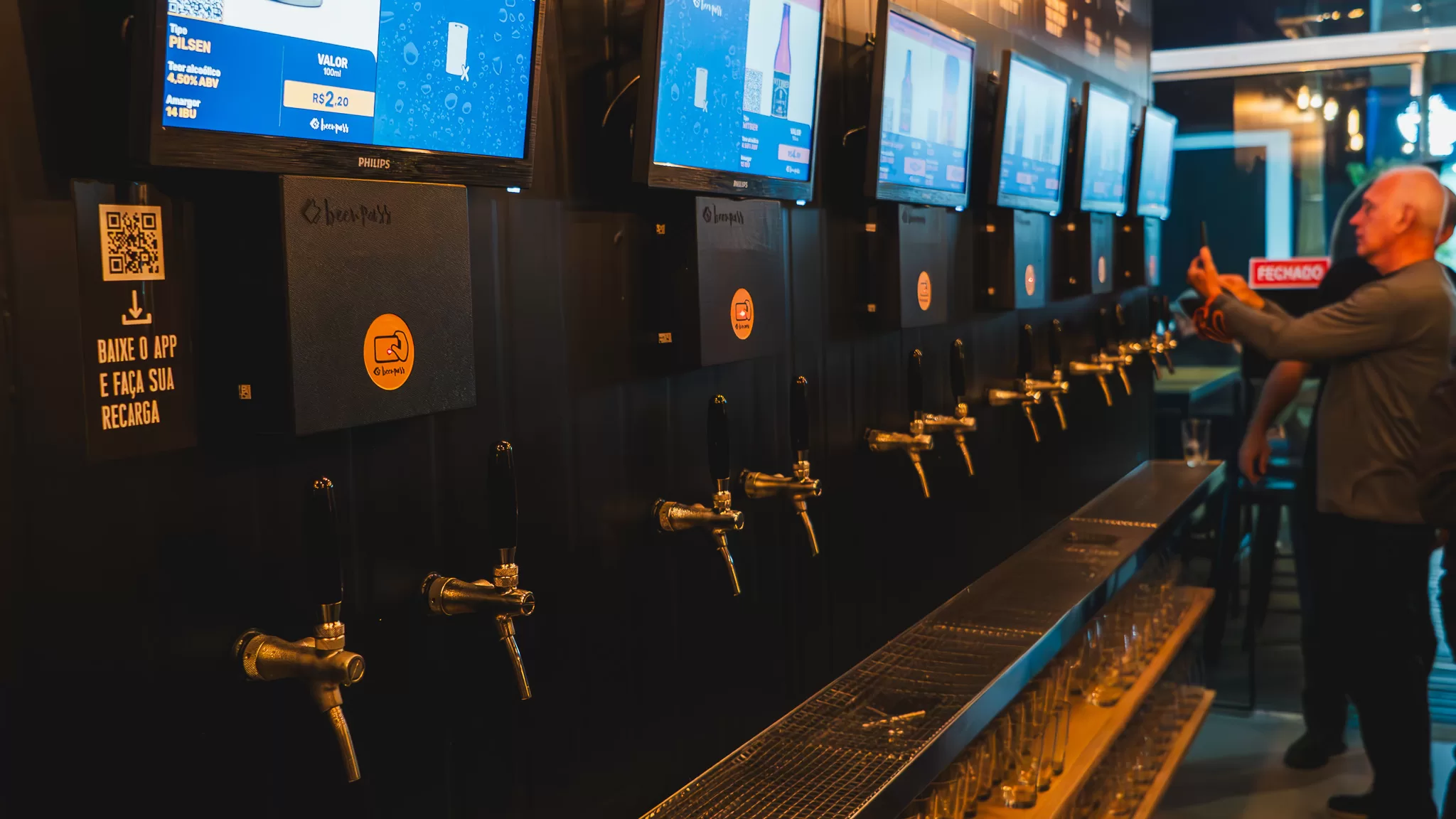 cliente utilizando sistema de autosserviço de chope Beerpass em bar